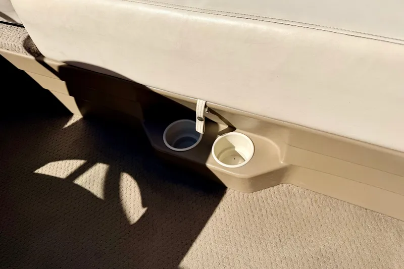 Slide: The Image of 2003 Glastron/Carlson GX180 interior with beige seating and cup holders. - 27