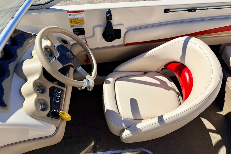 Slide: The Image of 2003 Glastron/Carlson GX180 boat interior with steering wheel and cushioned seat. - 28