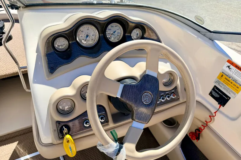 Slide: The Image of 2003 Glastron/Carlson GX180 boat dashboard with steering wheel and gauges. - 30