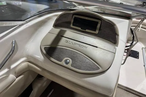 Slide: The Image of 2003 Glastron/Carlson GX180 boat on red trailer, parked near blue building. - 4