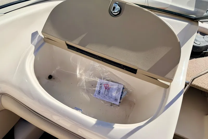 Slide: The Image of Open glove compartment in 2003 Glastron/Carlson GX180 boat, containing a plastic bag and manual. - 40