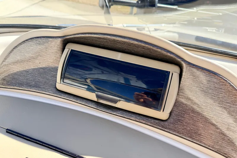 Slide: The Image of 2003 Glastron/Carlson GX180 dashboard with a closed compartment, reflecting sunlight. - 42