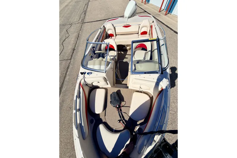 Slide: The Image of 2003 Glastron/Carlson GX180 boat interior with seating and steering wheel, parked on pavement. - 54