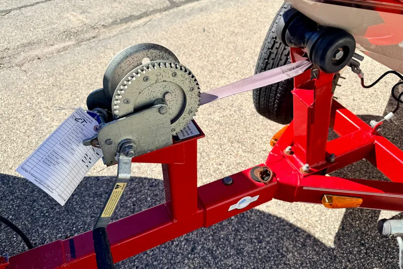 Slide: The Image of Red boat trailer with winch, attached to a 2003 Glastron/Carlson GX180. - 57