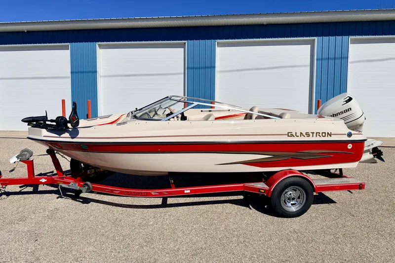 Slide: The Image of 2003 Glastron/Carlson GX180 boat on red trailer, parked outside blue building. - 59