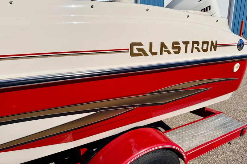 Slide: The Image of 2003 Glastron/Carlson GX180 boat with red and white design, side view. - 61