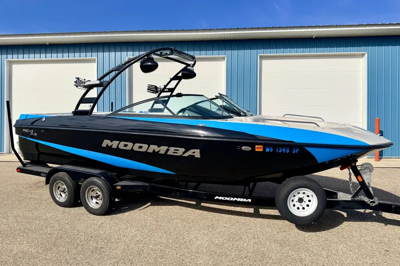 Slide: The Image of 2012 Moomba Mojo 2.5 boat with blue and black design on a trailer. - 0
