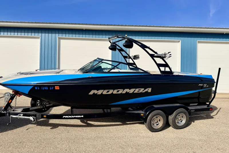 Slide: The Image of 2012 Moomba Mojo 2.5 boat on trailer, parked near blue building. - 1