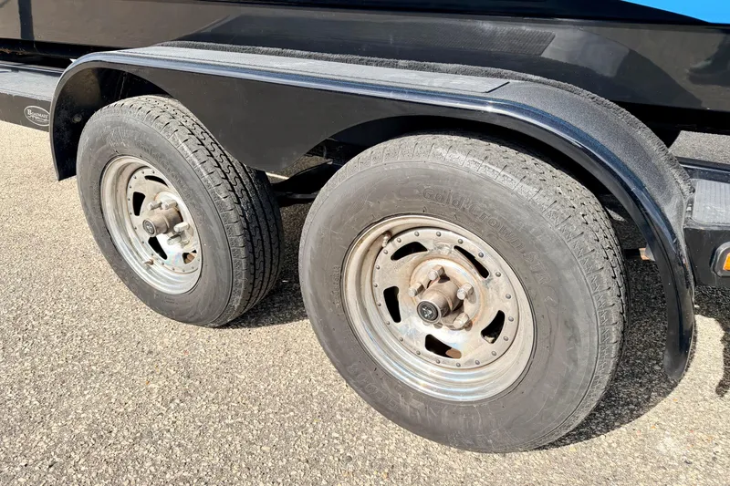 Slide: The Image of 2012 Moomba Mojo 2.5 trailer wheels on asphalt, showcasing dual tires and black fender. - 10