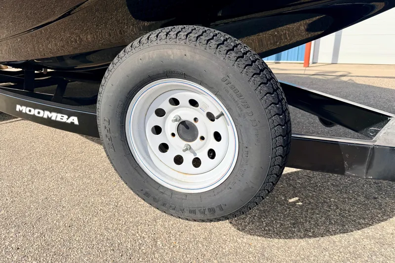 Slide: The Image of 2012 Moomba Mojo 2.5 trailer tire on asphalt, showcasing brand and wheel design. - 11