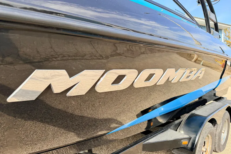 Slide: The Image of 2012 Moomba Mojo 2.5 boat with sleek black and blue design on trailer. - 3