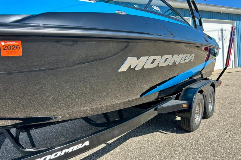 Slide: The Image of 2012 Moomba Mojo 2.5 boat on trailer, parked outside blue building. - 43