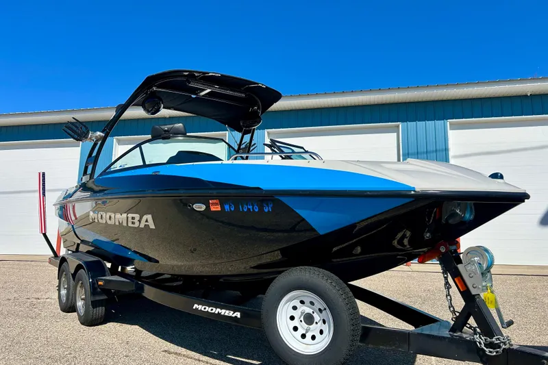 Slide: The Image of 2012 Moomba Mojo 2.5 boat on trailer, parked outside blue building. - 73