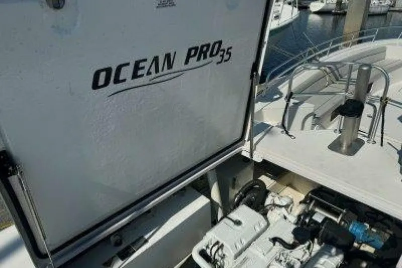 Slide: The Image of 2019 OceanPro 35 boat engine compartment at marina, showcasing brand and model details. - 10