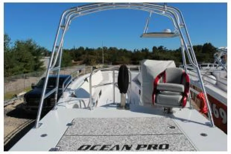 Slide: The Image of 2019 OceanPro 35 boat with seating and open deck, parked outdoors. - 7