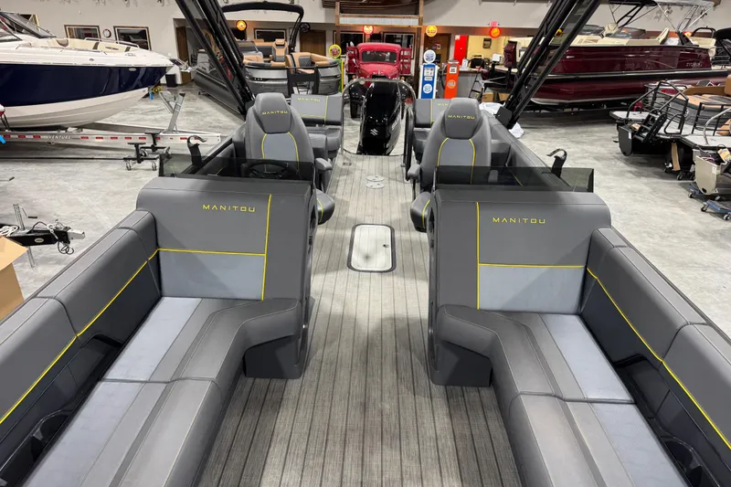 Slide: The Image of 2025 Manitou 24 Explore pontoon boat interior with gray seating and yellow accents. - 10