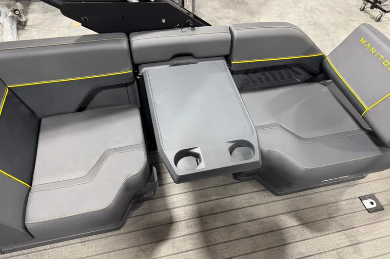 Slide: The Image of 2025 Manitou 24 Explore boat seating with gray upholstery and integrated cup holders. - 14