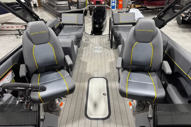 Slide: The Image of 2025 Manitou 24 Explore boat interior with gray seating and yellow accents. - 9