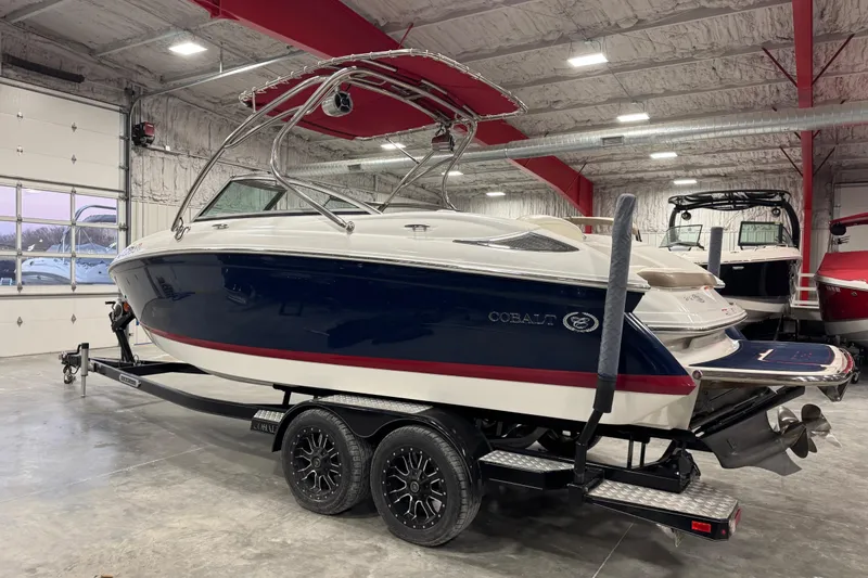 Slide: The Image of 2012 Cobalt 242 boat in a garage, featuring a sleek design and dual-axle trailer. - 4