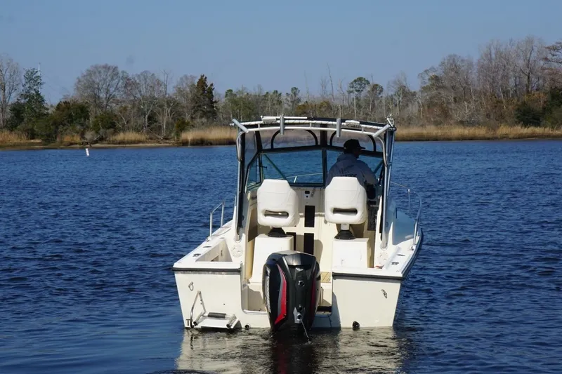 Slide: The Image of 1996 Parker 2110 boat on calm water with trees in the background. - 1