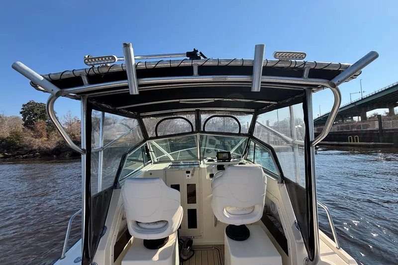 Slide: The Image of 1996 Parker 2110 boat interior with dual seats, navigating a river near a bridge. - 11