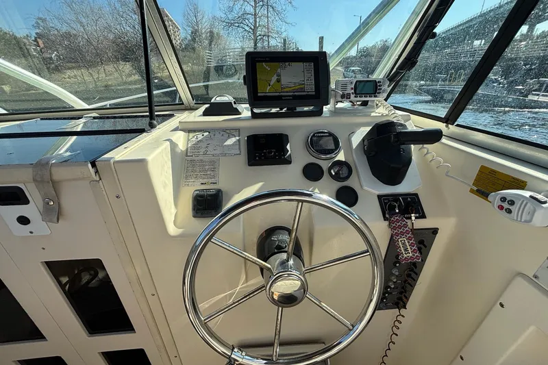 Slide: The Image of 1996 Parker 2110 boat dashboard with steering wheel, navigation equipment, and control panel. - 17