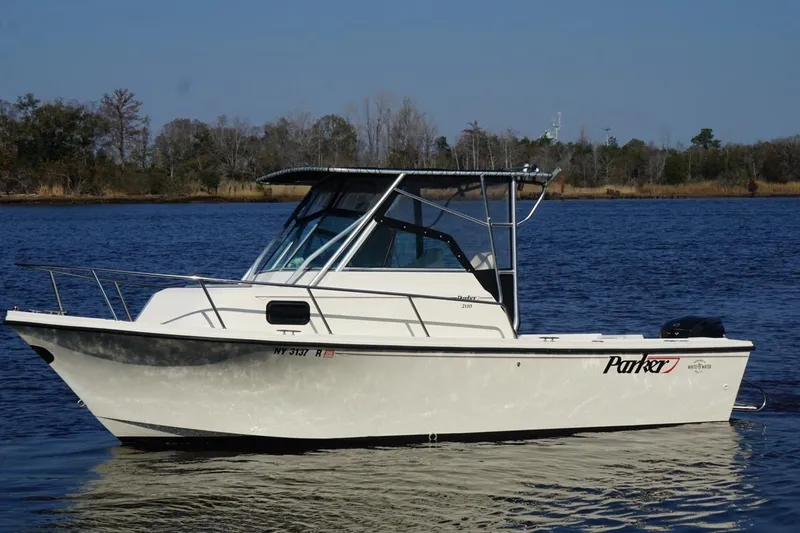 Slide: The Image of 1996 Parker 2110 boat on calm water, side view with trees in background. - 5
