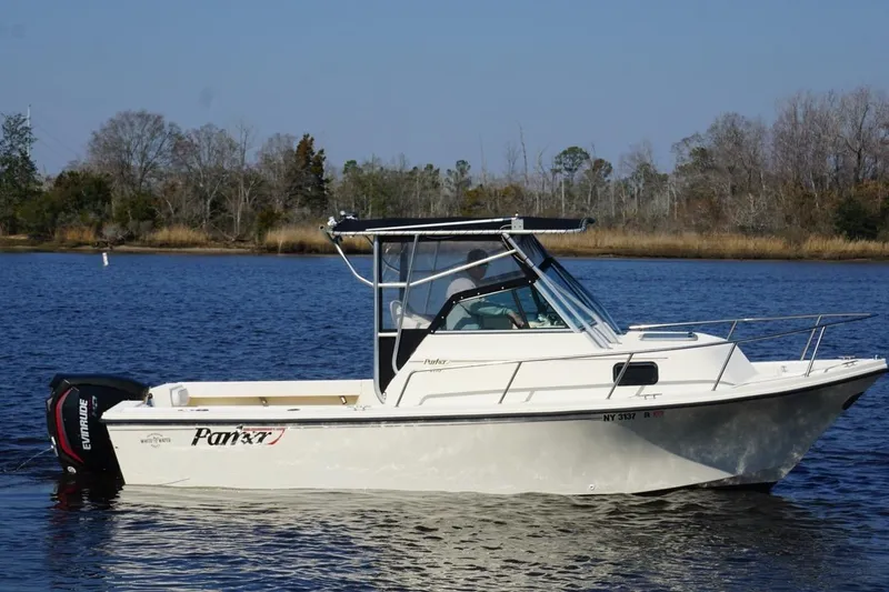 Slide: The Image of 1996 Parker 2110 boat on calm water with trees in the background. - 9