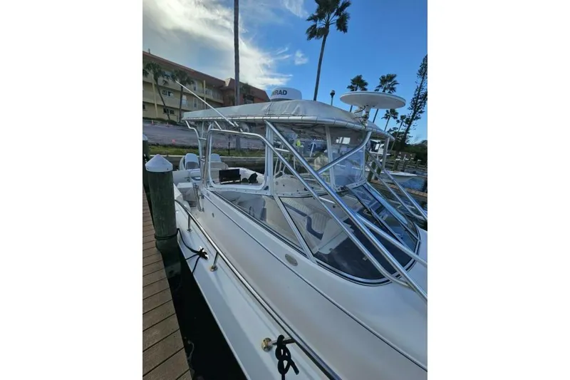 Slide: The Image of 2004 Pro-Line 30 Express Walkaround boat docked, featuring sleek design and spacious cockpit. - 3