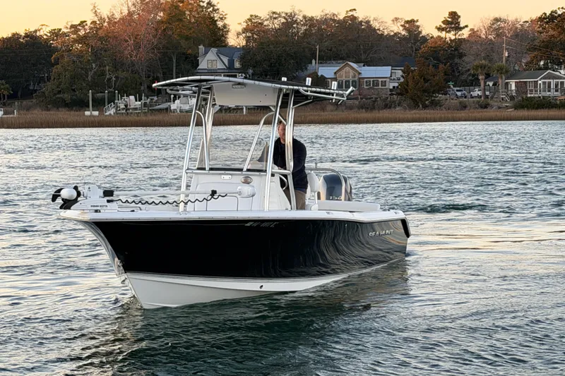 Slide: The Image of 2014 Sea Hunt Ultra 211 boat on calm water at sunset. - 10