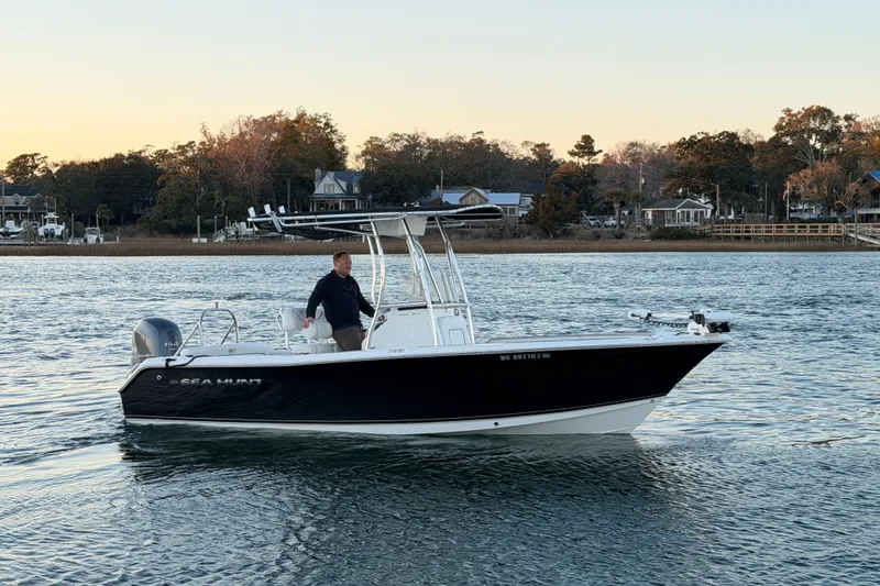 Slide: The Image of 2014 Sea Hunt Ultra 211 boat on calm water at sunset. - 2