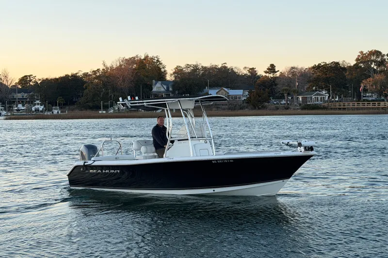 Slide: The Image of 2014 Sea Hunt Ultra 211 boat on calm water at sunset. - 3