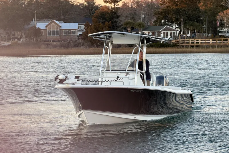Slide: The Image of 2014 Sea Hunt Ultra 211 boat cruising on a calm river near a scenic shoreline. - 31