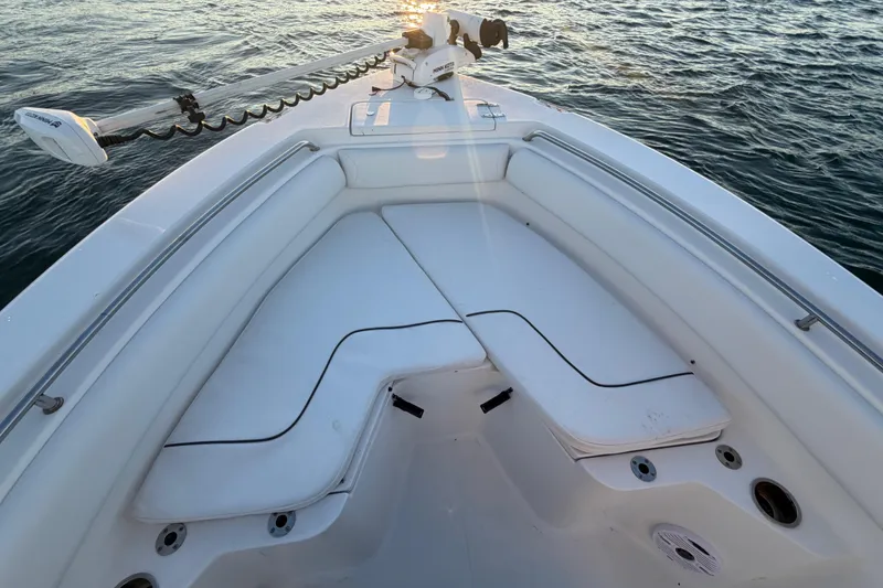 Slide: The Image of 2014 Sea Hunt Ultra 211 boat interior with cushioned seating and trolling motor on calm water. - 33