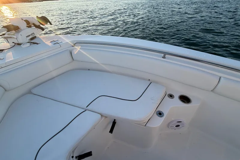 Slide: The Image of 2014 Sea Hunt Ultra 211 boat interior with seating, on calm water at sunset. - 34