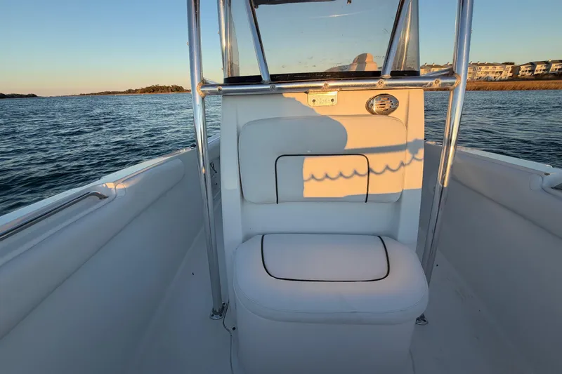 Slide: The Image of 2014 Sea Hunt Ultra 211 boat interior with seating, on calm water at sunset. - 39