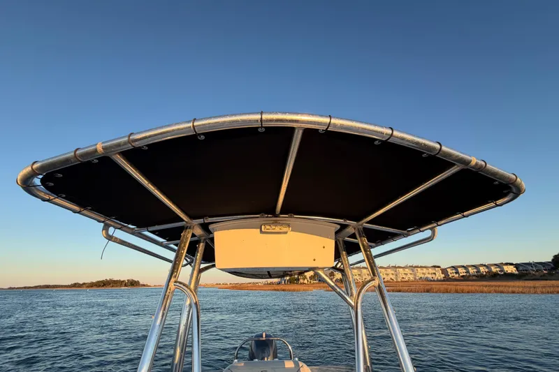 Slide: The Image of 2014 Sea Hunt Ultra 211 boat with T-top on calm water at sunset. - 40