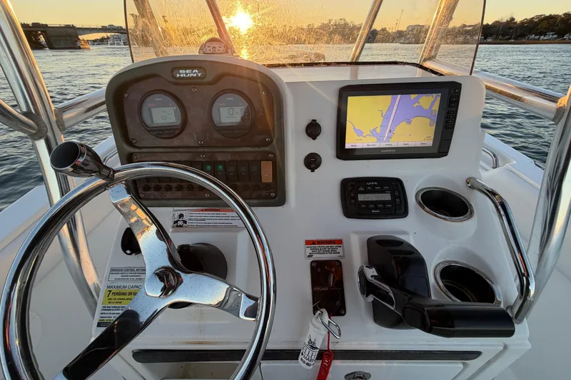 Slide: The Image of 2014 Sea Hunt Ultra 211 boat dashboard with steering wheel and navigation system at sunset. - 41