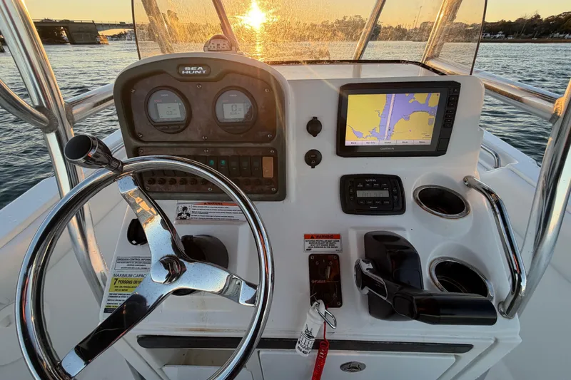 Slide: The Image of 2014 Sea Hunt Ultra 211 boat dashboard with steering wheel and navigation system at sunset. - 43