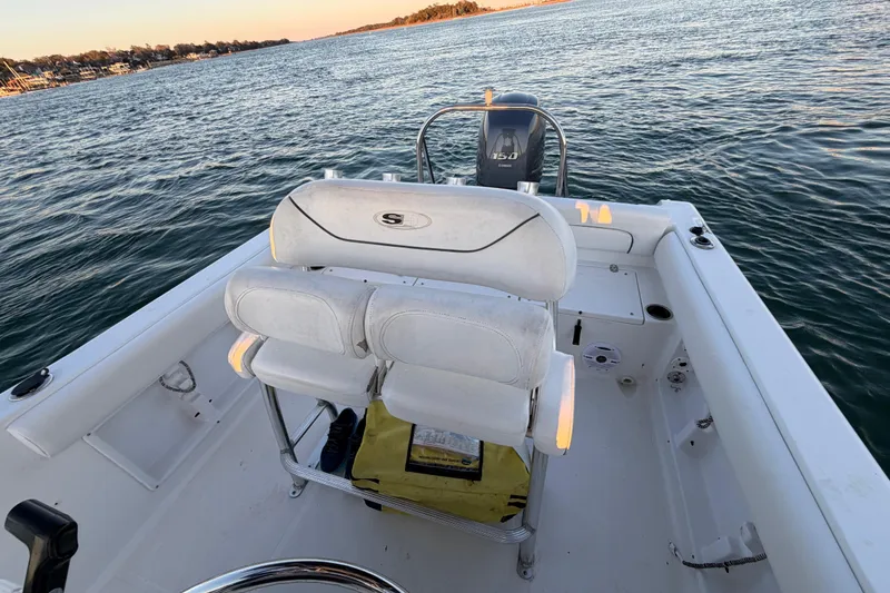 Slide: The Image of 2014 Sea Hunt Ultra 211 boat interior with seating and Yamaha engine on water. - 48