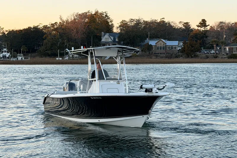 Slide: The Image of 2014 Sea Hunt Ultra 211 boat on calm water near shoreline at sunset. - 5