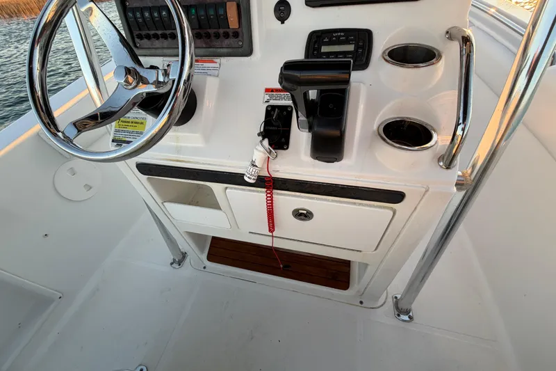 Slide: The Image of 2014 Sea Hunt Ultra 211 boat console with steering wheel and controls. - 52