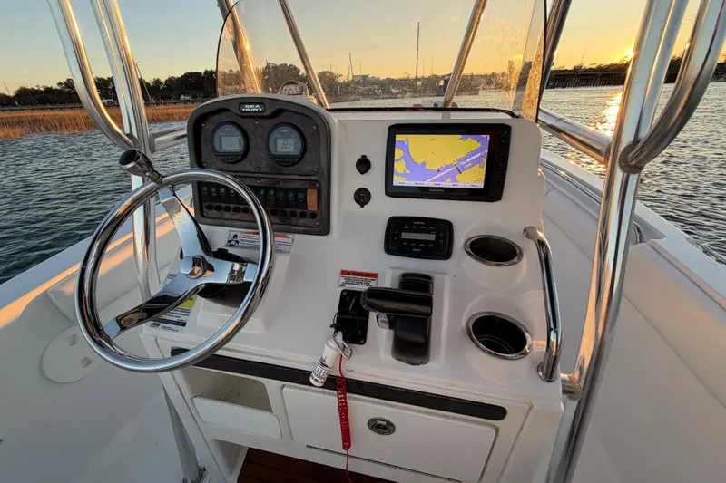 Slide: The Image of 2014 Sea Hunt Ultra 211 boat console with steering wheel and navigation system at sunset. - 53