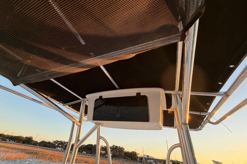 Slide: The Image of 2014 Sea Hunt Ultra 211 boat canopy and storage compartment at sunset. - 54
