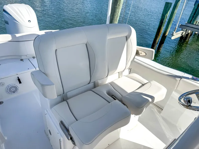 Slide: The Image of 2023 Sea Hunt Ultra 239 SE boat seat by the water. - 19