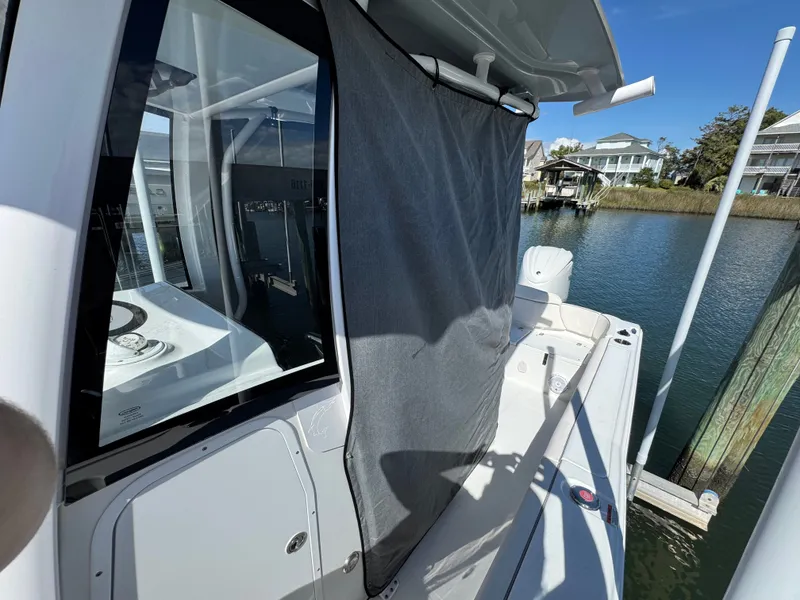 Slide: The Image of 2023 Sea Hunt Ultra 239 SE boat docked with gray curtain. - 38