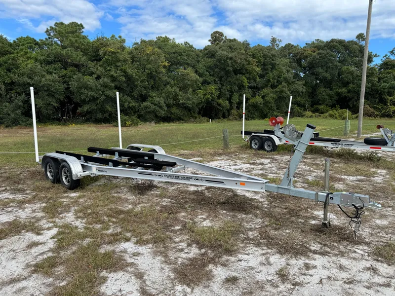 Slide: The Image of Boat trailer on grassy terrain surrounded by trees. - 43