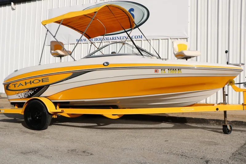 The Image of 2010 Tahoe Q5i SF boat with yellow accents and canopy on trailer. - 1