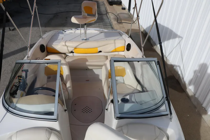 Slide: The Image of 2010 Tahoe Q5i SF boat interior with beige and yellow seating, windshield, and fishing chair. - 16