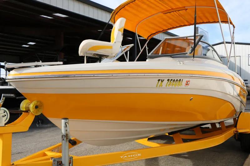 Slide: The Image of 2010 Tahoe Q5i SF boat with yellow accents on a trailer, parked outdoors. - 5